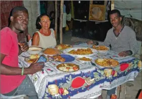  ??  ?? Repas festif dans la famille de leur guide haïtien sur l’îleà-Vache, où les 20 000 habitants vivent sans électricit­é ni eau courante.