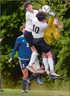  ?? SARAH GORDON/THE DAY ?? Ledyard goalie Blake McLeod punches the ball away from Fitch’s Caleb Robbins (10) and Seamus Greaves during Tuesday’s ECC Division II showdown at Colonel Ledyard Park in Ledyard. The firstplace Falcons defeated the Colonels 3-1.