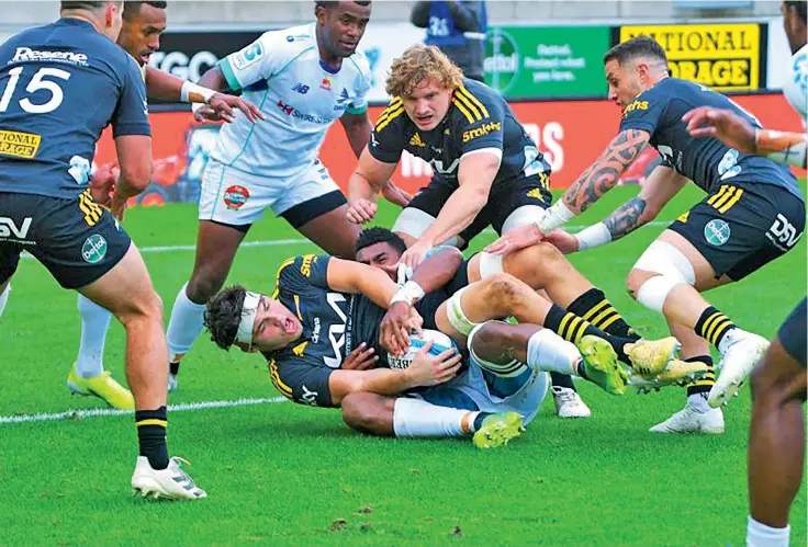  ?? Photo: AFP ?? Hurricanes’ Tyler Laubscher, centre bottom, is tackled by Swire Shipping Fijian Drua flanker Kitione Salawa in their Super Rugby match in Wellington on May 8, 2022.