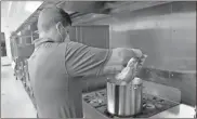  ?? Olivia Morley ?? Elliott Rank, an employee in the Kerry plant’s human resources department, pours rice into boiling water to begin preparing smothered chicken enchiladas. Plans were to deliver 100 meals to Restoratio­n Rome to give to foster families.