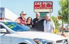  ?? GLEN ROSALES/FOR THE JOURNAL ?? Joe and Linda Page, at left, recently sold a portion of their stake in Car Pros Auto Sales to auto sales veterans Hubert Little, third from left, and Klint Kelly.