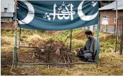  ?? THE NEW YORK TIMES ?? A relative visits the grave of Numan Ashraf Bhat, who was shot at 16 while trying to aid a militant.