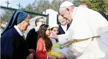  ?? — Reuters photo ?? Pope Francis greets a girl during a visit to a rural social service run by the Daughters of Charity of St. Vincent de Paul in Temara, near Rabat, Morocco.