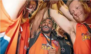  ?? PHOTOSPORT ?? Sharks’ Tinashe Matambanad­zo celebrates with team-mates after their NBL grand final victory over the Wellington Saints at the TSB Arena yesterday. At right, Reuben Te Rangi cuts the net to keep as a souvenir. Te Rangi was in top form for the Sharks,...