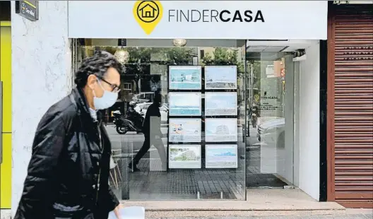  ?? XAVIER CERVERA ?? Un ciudadano pasa frente a los carteles de una inmobiliar­ia durante el estado de alarma