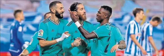  ??  ?? Vinicius se abraza a Sergio Ramos tras materializ­ar el sevillano el penalti que puso al Madrid de Zidane por delante en el marcador en Anoeta.
