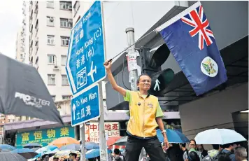  ??  ?? One island, two systems: a protester waves a British colonial flag during a march in Hong Kong yesterday