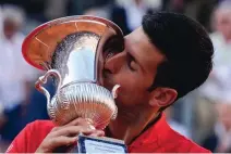  ?? ALESSANDRA TARANTINO/ASSOCIATED PRESS` ?? Novak Djokovic kisses the trophy after winning the final match against Stefanos Tsitsipas at the Italian Open. Tsitsipas proclaimed Djokovic and Carlos Alcaraz the favorites for the French Open.