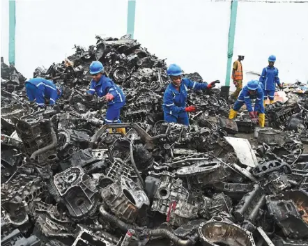  ?? —afp ?? Workers gather piles of scrap automobile aluminium and metals for recycling at the romco factory in Lagos.