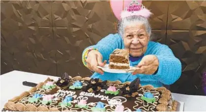  ?? MARCUS SANTOS / NEW YORK DAILY NEWS ?? Amparo Perez holds a slice of her birthday cake during her 104th birthday party in the Bronx.