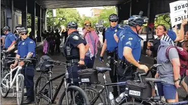  ?? CORNELIUS FROLIK / STAFF ?? Protesters pushed through a line of police officers on East Fifth Street on May 30.