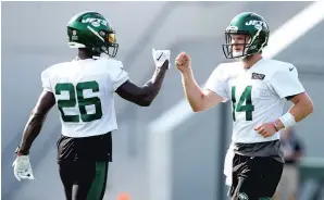  ?? MIKE STOBE / GETTY ?? Le’Veon Bell and Sam Darnold fist bump during training camp at Atlantic Health Jets Training Center on Aug. 14, in Florham Park, New Jersey.