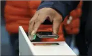  ?? ELAINE THOMPSON — THE ASSOCIATED PRESS FILE ?? Ashopper scans an Amazon Go app on a cellphone while entering an Amazon Go store in Seattle. Get ready to say good riddance to the checkout line.