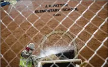  ?? TAMIR KALIFA / AMERICAN-STATESMAN ?? A masonry worker cleans a cement mixer at J.A. Patton Elementary School on Thursday. The school’s renovation­s, repairs and expansion were funded by a 2013 bond package.