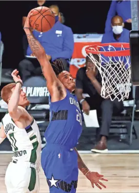  ?? KIM KLEMENT/USA TODAY SPORTS ?? Magic forward Al-farouq Aminu dunks the ball past Milwaukee Bucks guard Donte Divincenzo during Game 5 of the teams’ first-round playoff series Saturday in Lake Buena Vista, Fla.