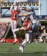  ?? Michael Dwyer / Associated Press ?? Patriots cornerback Jack Jones (13) intercepts a pass intended for Lions tight end T.J. Hockenson as Patriots linebacker Jahlani Tavai (48) defends during the first half on Sunday in Foxborough, Mass.