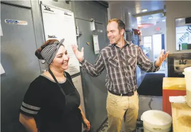  ?? Jim Gensheimer / Special to The Chronicle ?? Zachary Davis, owner of the Penny Ice Creamery in Santa Cruz, talks with employee Monique Plossl. Davis is one of the first 20 employers to register in the state’s CalSavers retirement savings program.