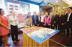  ?? PIC BY L. MANIMARAN ?? Deputy Health Minister Dr Lee Boon Chye signing a book replica after a luncheon with the Perak Chinese Schools Council Committee in Ipoh yesterday.