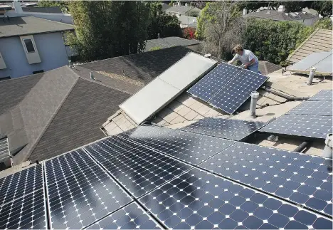  ?? DAVID MCNEW/FILES ?? U.S. developers are adding workers at a record pace to install solar rooftop panels, thanks to state initiative­s to spur clean energy.