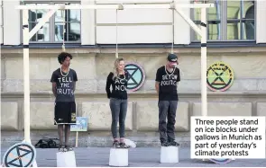  ??  ?? Three people stand on ice blocks under gallows in Munich as part of yesterday’s climate protests