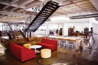  ?? Michael Ciaglo / Houston Chronicle ?? The third floor at the new Houston Chronicle building features a wood and iron staircase to the fourth floor. Conversati­on areas encourage teamwork with comfortabl­e chairs and long tables.