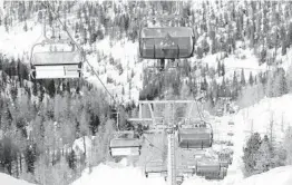  ?? ANTONIO CALANNI/AP ?? A skier sits on one of the few chairlifts open Jan. 28 in Cortina d’Ampezzo, Italy. The pandemic has ravaged the local economy, which leans heavily on ski season.