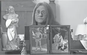  ?? CHRIS CROOK/TIMES RECORDER ?? Teresa Confer looks at pictures of her husband, Marion “Buddy” Wilson. Wilson went missing in Vietnam on Feb. 3, 1968. They had been married for 16 days before his deployment.