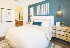  ??  ?? Hardwood flooring lines this bedroom with an en suite bathroom at the Mockingbir­d Lane community in Sonoma.