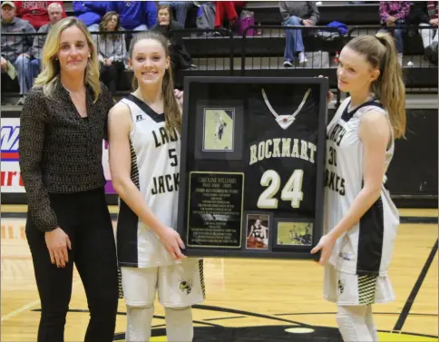  ?? Kevin Myrick / SJ ?? Caroline Williams Hipps stands with Mollie and Megan Little after being presented with her retired number from Rockmart High School’s girls basketball program on Feb. 2.