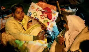  ?? AP ?? A mother holds her sleeping child at a makeshift camp on a football field in Durres, following the deadly earthquake that shook Albania.