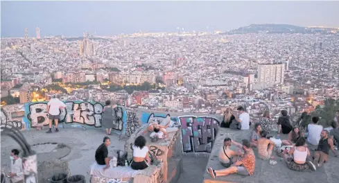  ?? REUTERS ?? Tourists and locals in Spain gather at a lookout point, with a view of the city of Barcelona, after regional authoritie­s there introduced fresh coronaviru­s disease restrictio­ns.