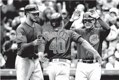  ?? Associated Press ?? Chicago Cubs’ Willson Contreras, center, celebrates with Kris Bryant, left, and Anthony Rizzo after hitting a grand slam off Cincinnati Reds starting pitcher Cody Reed on Saturday during the second inning in Cincinnati. The Cubs have won 20 of their...