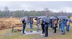  ?? FOTO: OLE SPATA ?? Guide Jakob Rühe (l.) steht mit den Abiturient­en aus Lübbecke neben dem Gedenkstei­n für Margot und Anne Frank.