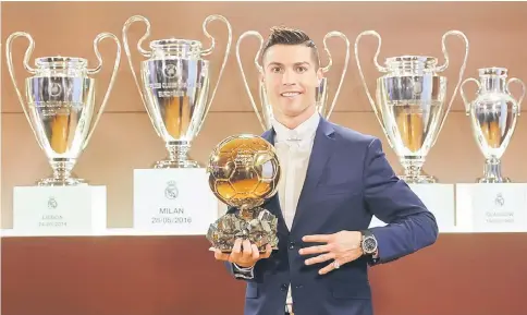  ??  ?? Cristiano Ronaldo posing with the Ballon d’Or France Football trophy at the Trophy Room of the Santiago Bernabeu stadium in Madrid. — AFP photo