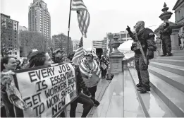  ?? MATTHEW DAE SMITH/LANSING STATE JOURNAL ?? Protesters rally to denounce Gov. Gretchen Whitmer’s stay-at-home order and business restrictio­ns due to COVID-19 on April 30 at the state Capitol in Lansing, Michigan.