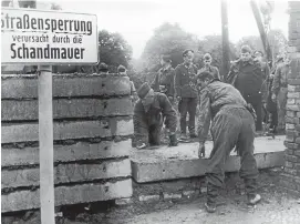  ?? Picture: GETTY IMAGES ?? ANOTHER BRICK IN THE WALL: East German soldiers erect the barrier in 1961