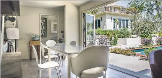  ?? Photograph­s by Maria Alejandra Cardona Los Angeles Times ?? THE SHARED outdoor kitchen that Patty Lombard and her husband created for her parents and other family members opens to the pool and raised planters.