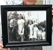 ??  ?? Gwen Boivin holds a framed photo of herself and her six siblings, who all grew up outside of Moose Jaw.