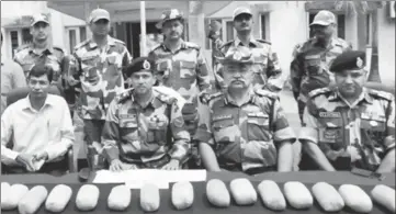  ?? HT PHOTO ?? Border Security Force and Narcotics Control Bureau personnel with the seized contraband in Tarn Taran on Wednesday.