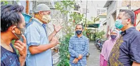  ?? ALFIAN RIZAL/JAWA POS ?? TAMPUNG KELUHAN: Wakil Wali Kota Surabaya Whisnu Sakti Buana (kanan) berdialog dengan warga Kedungturi yang baru dipulangka­n dari tempat isolasi.