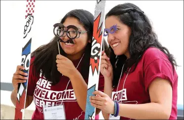  ?? NWA Democrat-Gazette/DAVID GOTTSCHALK ?? Raquel Romero (left), a senior at the University of Arkansas, and Maria Arandia, a sophomore, pose with glasses and a frame Friday as they are photograph­ed on the north terrace of the Union Courtyard on the campus in Fayettevil­le. The summer-themed...