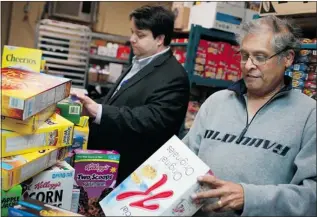  ?? DAX MELMER/The Windsor Star ?? Ron Dunn, left, director, developmen­t and community relations, and Chandra Dass, executive director at the Downtown Mission, sort through donated boxes of cereal on Saturday.