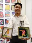  ?? — Bernama photo ?? Yuszairi shows a couple of bird-themed paintings done by him.