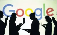  ?? PHOTO: REUTERS ?? Captured . . . Silhouette­s of device users in front of a screen projection of the Google logo.