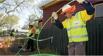  ?? Photo: Kevin Farmer ?? SWITCH ON: Gavin Phair (left) and Neville Pearson lay NBN cable in Toowoomba.