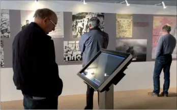  ?? CHINA DAILY ?? Visitors view historic photograph­s at the exhibition, Forgotten Camp, in San Francisco.