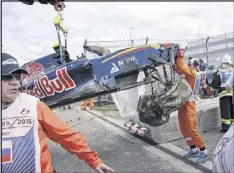  ?? IVAN SEKRETAREV / ASSOCIATED PRESS ?? Course marshals remove the car that Toro Rosso’s Carlos Sainz Jr. crashed during practice Saturday for the Russian Grand Prix in Sochi. Sainz skipped qualifying and was taken to a hospital as a precaution.