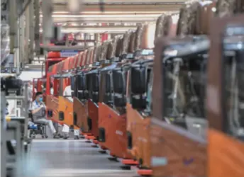  ??  ?? Workers assemble vehicles in an automobile workshop in Changchun, Jilin Province in northeast China, on June 19