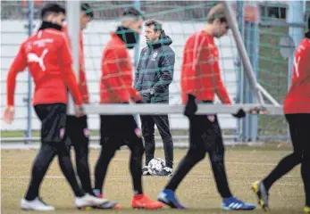  ?? FOTO: DPA ?? Noch standfest – Markus Weinzierl (Mi.) während dem Training auf dem Rasen in Bad Cannstatt.