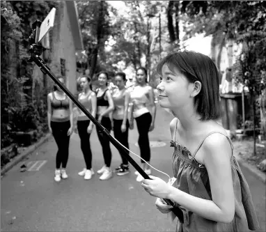  ?? CHENG YING / FOR CHINA DAILY ?? A girl hosts an online live show at a park in Wuhan, Hubei province.